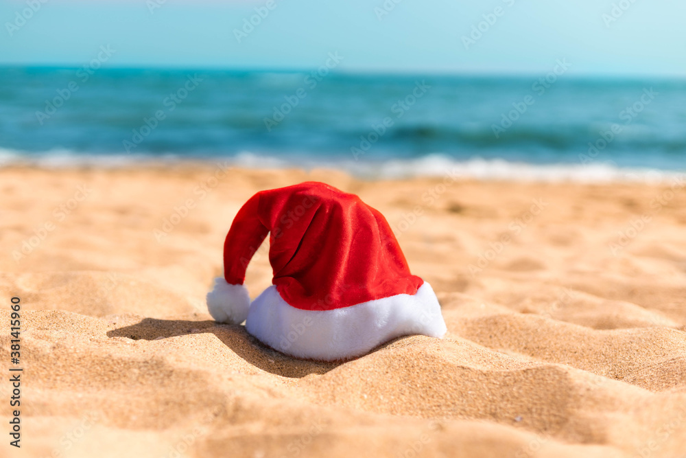 Santa hat on a tropical sea beach. Christmas beach vacation travel banner or card Santa hat on a tropical sea beach. Christmas beach vacation travel banner or card