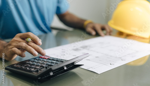 Foreman using calculator for analysis in the office 