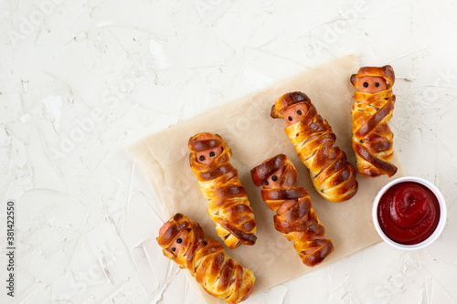 Scary sausage mummies in dough for kids party. Funny crazy Halloween food for children.