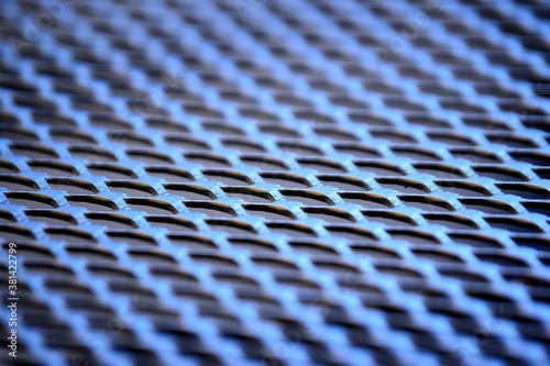 abstract view of a photographer on the lattice structure of a metal chair seat in a black design for an outdoor setting