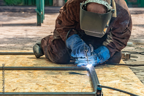 An electric welder assembles a metal structure from a shaped pipe by welding with an electrode.