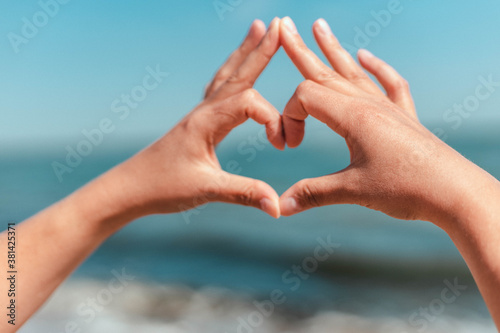 Human hands making heart shape on sea background © Shi 