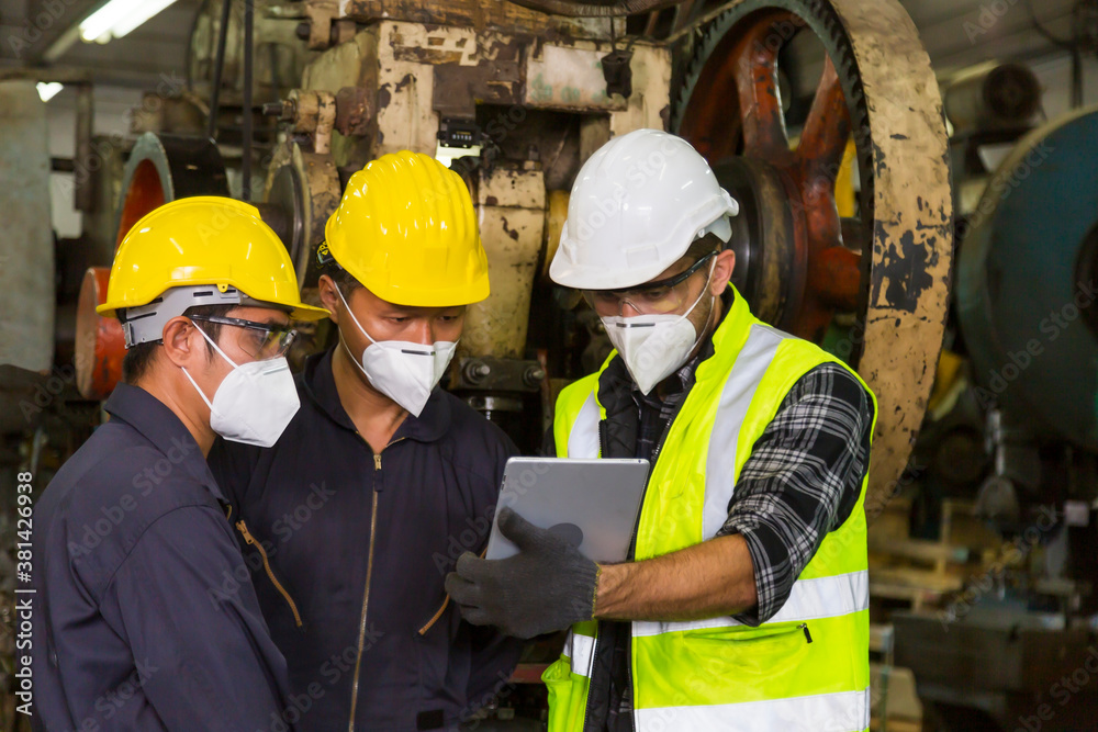 European engineers are discussing work with Asian technicians using tablets in the factory.
European engineers are discussing work with Asian technicians using tablets in the factory.
