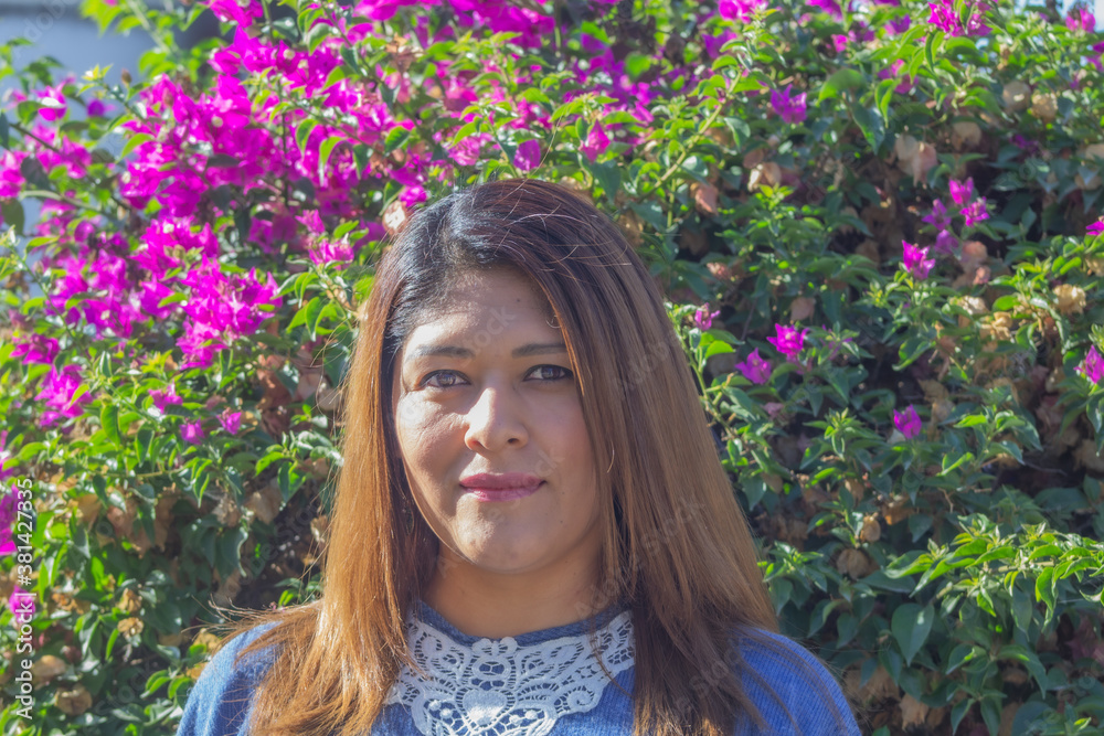 attractive mexican woman in front of pink flowers attractive mexican woman in front of pink flowers