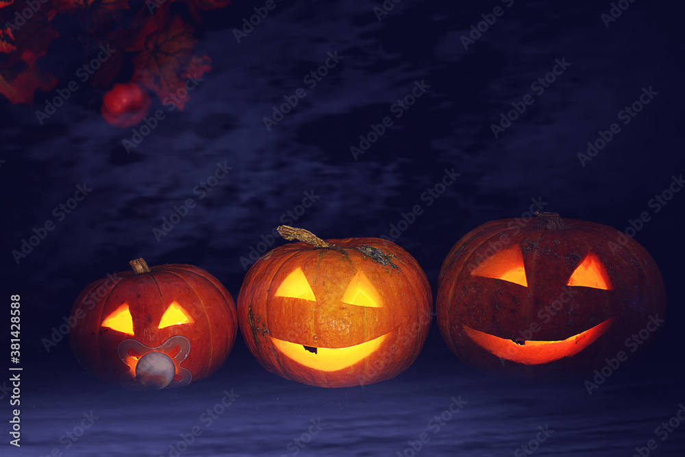 Halloween pumpkins with glowing eyes in a blue fog in the dark Halloween pumpkins with glowing eyes in a blue fog in the dark