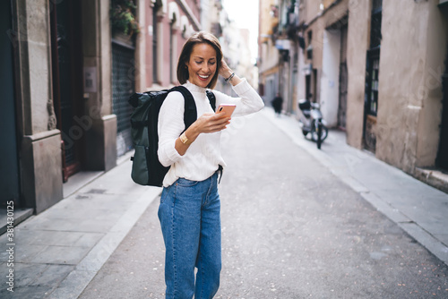 Positive woman using smartphone on street