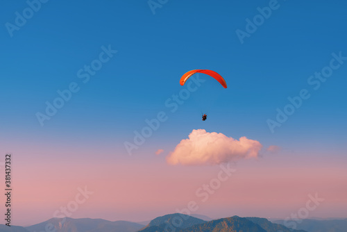 Paragliding against the sky during sunset. Flying over the mountains. Aircraft. Paraglider above the cloud.
