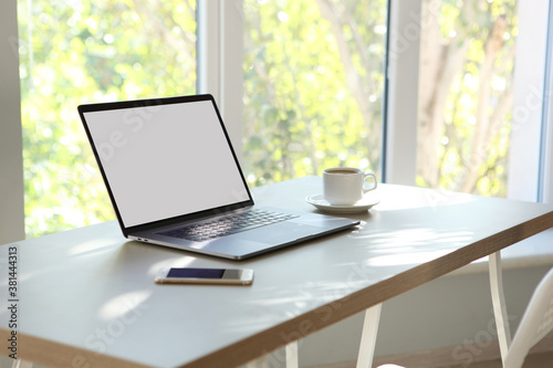 Workplace with modern laptop in the interior of the room