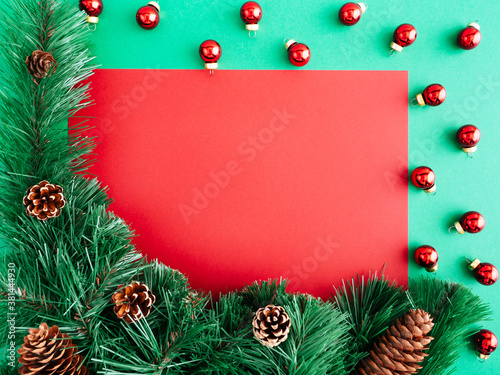 New year or Christmas layout  flatly  copy space. Christmas frame of Christmas trees and decorations on a green background  place for text on a red background. Layout for a greeting card