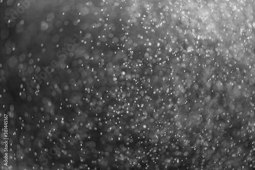 snow or rain bokeh texture overlay on black background. © iloli