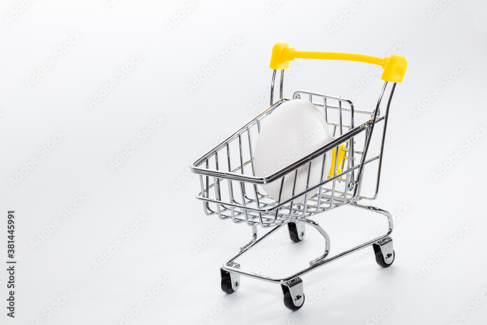 Single fresh egg in a shopping cart. Shopping, purchasing, and food delivery concept. Copy space.