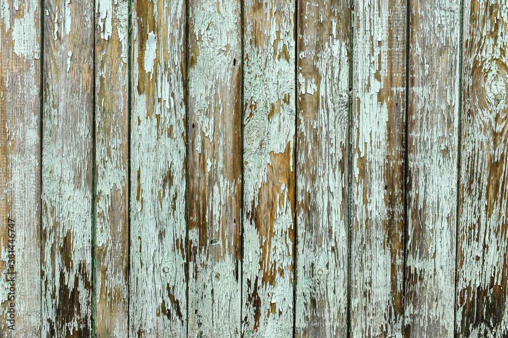 The texture of the wooden planks has faded in the sun. Wooden wall in gray-brown tones. Old wood background, board textures with peeling paint. Brown wood texture.