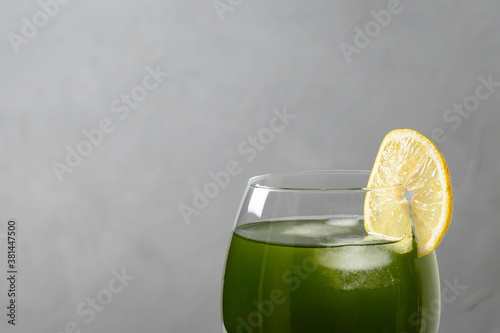 Chlorella healthy beverage in glass on a grey background. photo