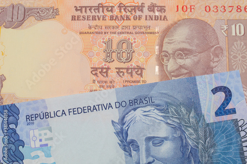 A macro image of a orange ten rupee bill from India paired up with a blue two real bank note from Brazil. Shot close up in macro.