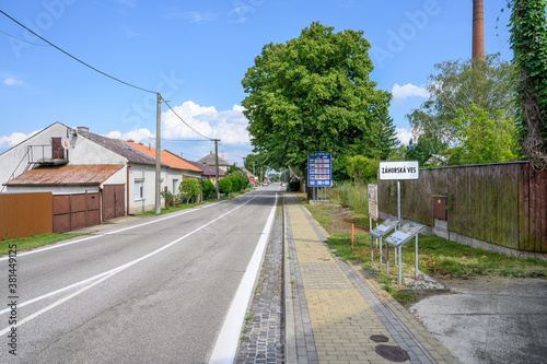 Entrance road to village Zahorska Ves with big blue board with speed limits in Slovakia (SLOVAKIA)