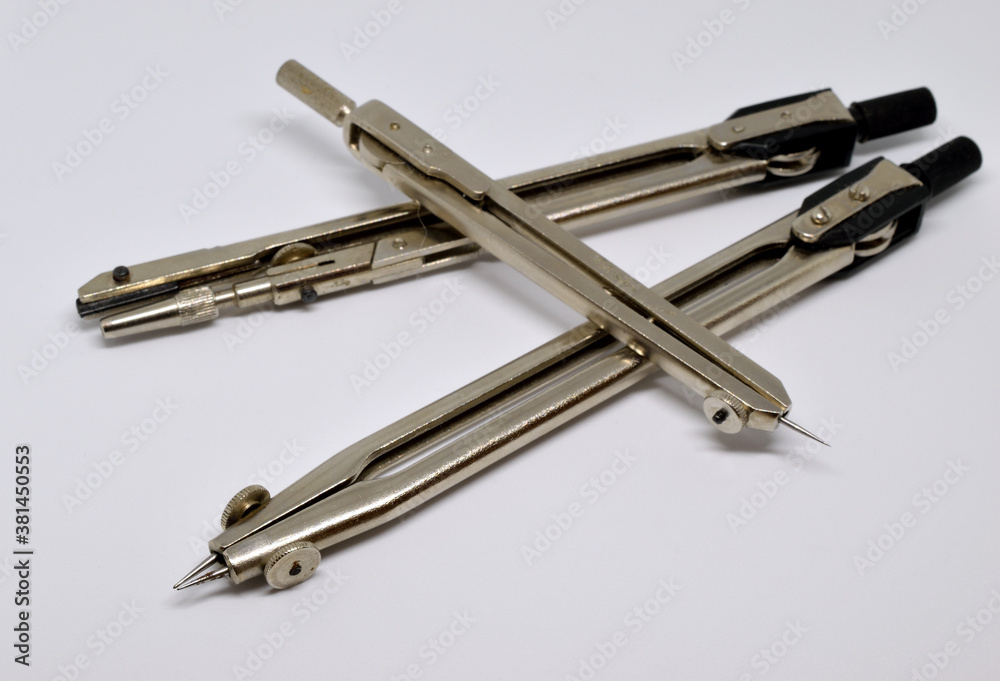 Three compasses on a white background. Isolated, close-up. Three compasses on a white background. Isolated, close-up.
