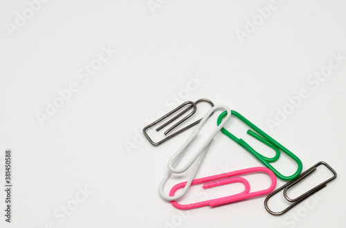 Five paper clips. White background, close-up, isolated.