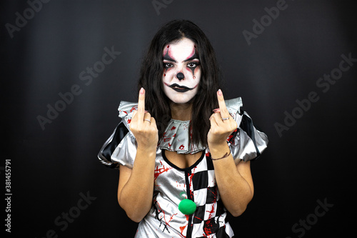 woman in a halloween clown costume over isolated black background showing middle finger doing fuck you bad expression, provocation and rude attitude. screaming excited