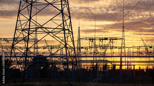 Power plant transmission infrastructure silhouettes at sunset.