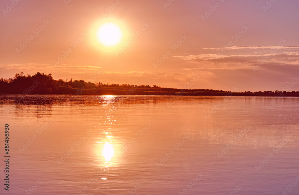 Calm expanse of a wide river in the light of the rising sun Calm expanse of a wide river in the light of the rising sun