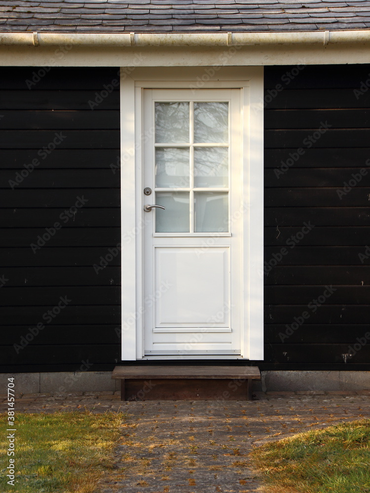 Fototapeta premium Isolated White Door on Black Wooden House
