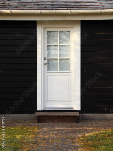 Isolated White Door on Black Wooden House