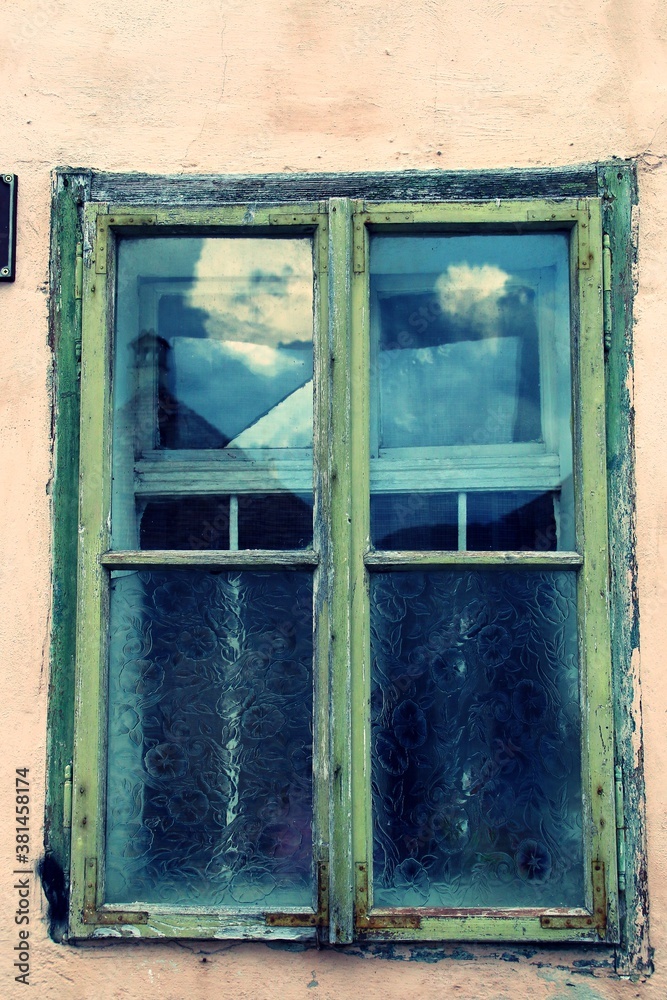 Exterior de una vieja ventana de madera. Ventana de vidrio desgastada por el efecto del sol, frío y la lluvia.