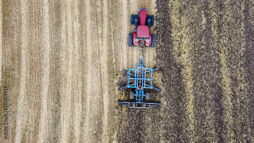 Aerial view of tractor or combine harvester works in field. Industrial agriculture © Garmon