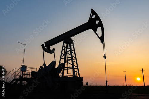 Oil pump at sunset in the field