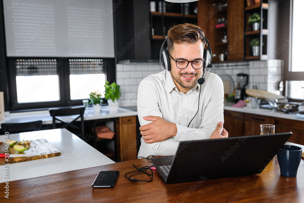 Young handsome man working from home, sitting in front of laptop computer having meeting over internet. Businessman freelance entrepreneur. Young handsome man working from home, sitting in front of laptop computer having meeting over internet. Businessman freelance entrepreneur.