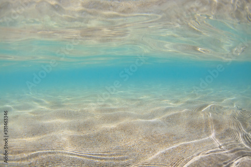 Underwater view of sand beach in sea tropical lagoon with clear turquoise water. Natural background
