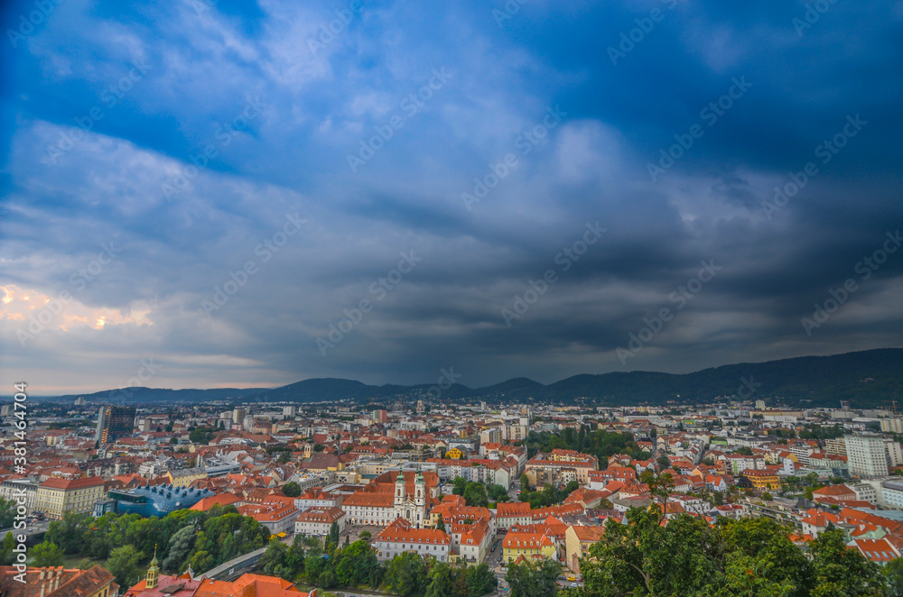 Storm with dramatic clouds over the city of Graz, with Mariahilfer church and historic buildings, in Styria region, Austria
