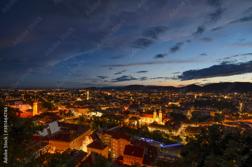 Cityscape of Graz with Mariahilfer church and historic buildings, in Graz, Styria region, Austria, by night.