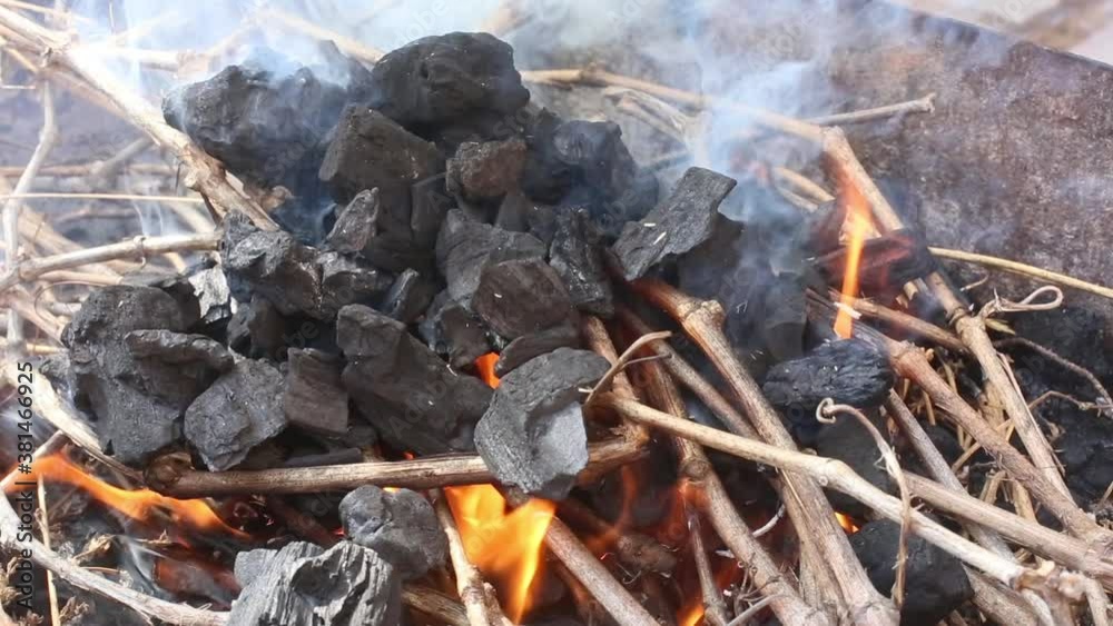 Flame flares up on coals for outdoor cooking Flame flares up on coals for outdoor cooking