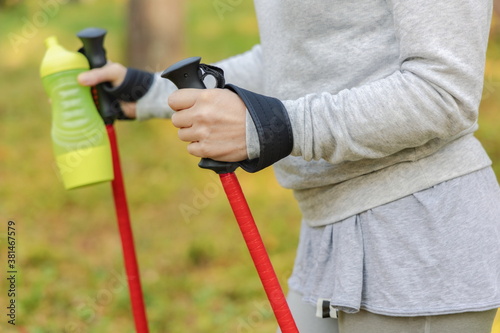 Woman with trekking poles and bottle of water