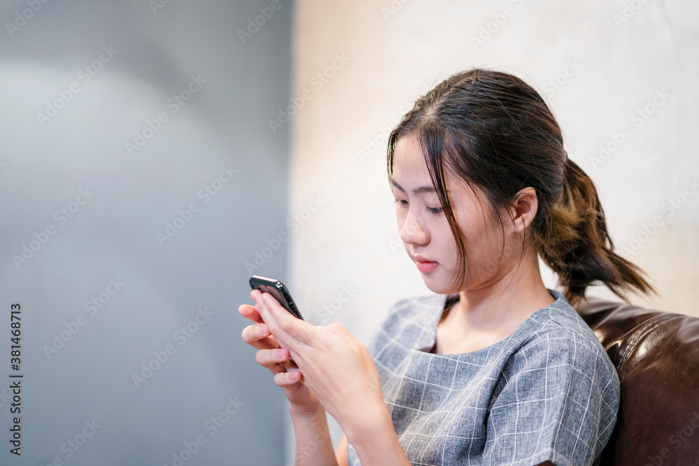 Social Media Technology Asian attractive girl smiling at home using smart phone mobile playing contacting online internet communication with people socializing in living room portrait copy space Social Media Technology Asian attractive girl smiling at home using smart phone mobile playing contacting online internet communication with people socializing in living room portrait copy space