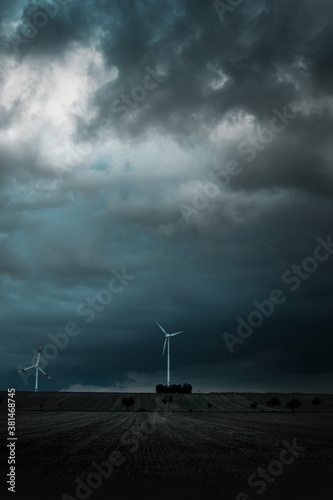 Wind turbine with dramatic stormy thunder weather with dark clouds in the german countryside