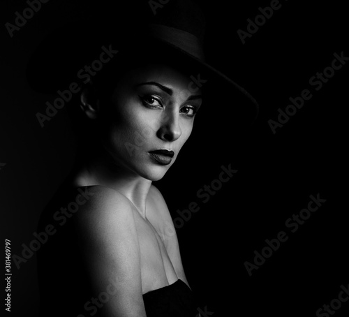 Beautiful glamour brunette woman with red lipstick in fashion hat on black background with empty copy space. Closeup portrait. Art.Expression.
