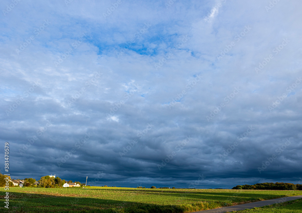 Naklejka premium There are large and beautiful clouds over the green field