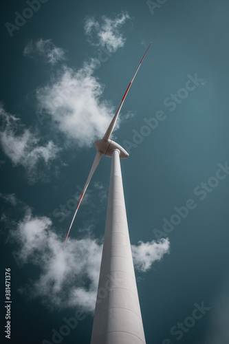 Wind park with wind turbines in the german countryside with fields and sunny weather. Wind creating renewable and sustainable electric power for the future