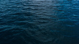 dark blue water background texture, turquoise water in the ocean, dark calm waves, relaxation and power concept