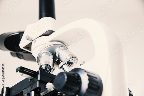 Using a biological microscope. Close up of a microscope. Scientific research concept, using a microscope. Medical examinations, searching for bacteria, diseases, blood tests.