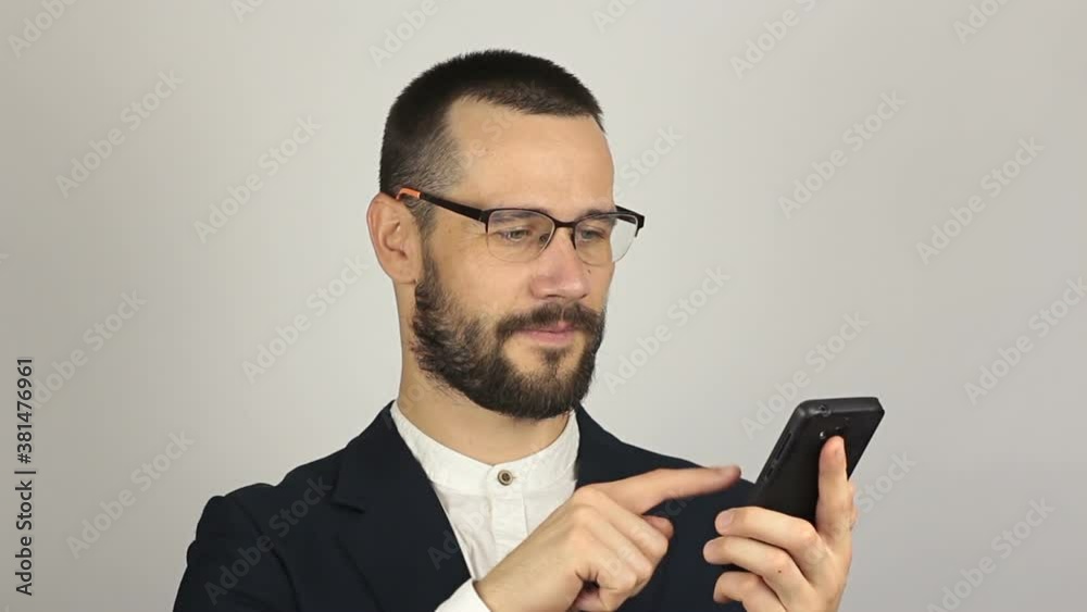 Young handsome businessman is viewing a news feed on his smartphone. Young handsome businessman is viewing a news feed on his smartphone.