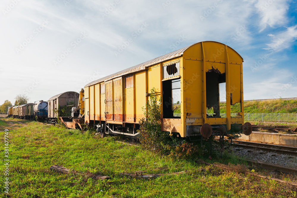 Old yellow train with big holes, rusty and abandoned on the old tracks in the field, on a bright summer day Old yellow train with big holes, rusty and abandoned on the old tracks in the field, on a bright summer day