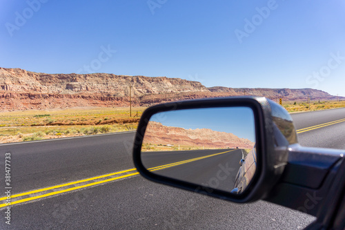 Road and landscape in rear vision mirror through Arizona.