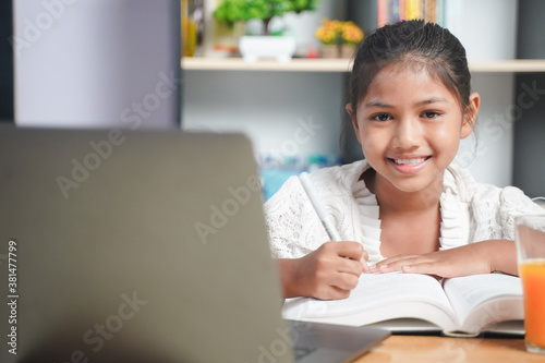 Happy Asian girl student online learning with laptop at home. class study online video call. Social distance  home schooler  New normal  Covid-19  Stay home.