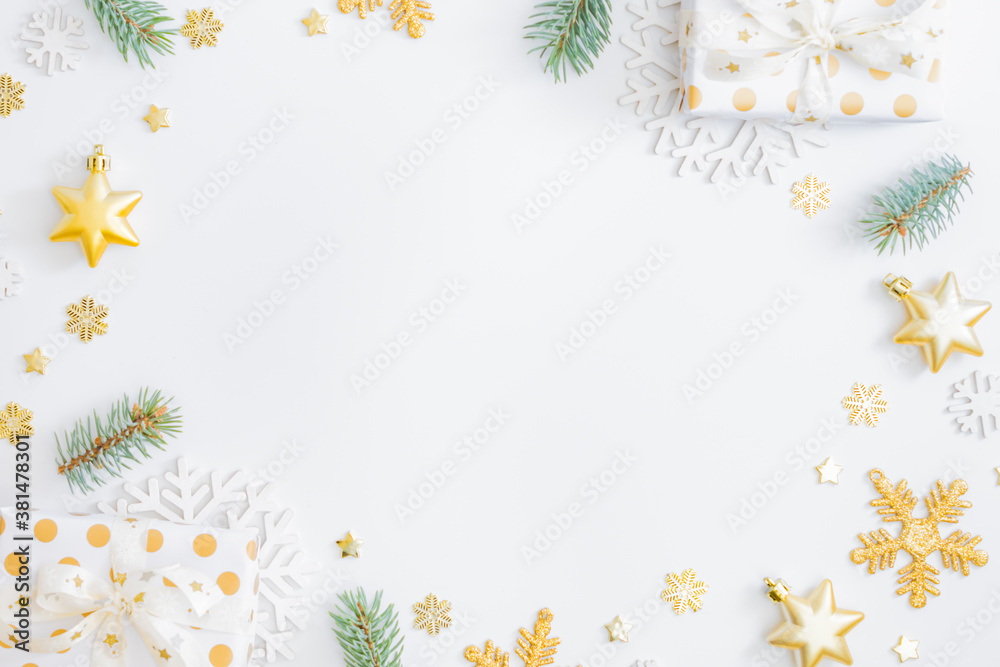 Flat lay frame with fir branches, christmas baubles decoration, gift box and snowflakes on a white background