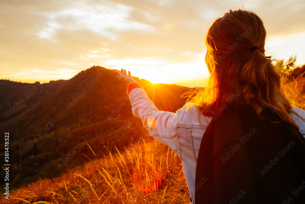 Carefree hipster girl enjoying nature on top of mountain with sunset. - obrazy, fototapety, plakaty 