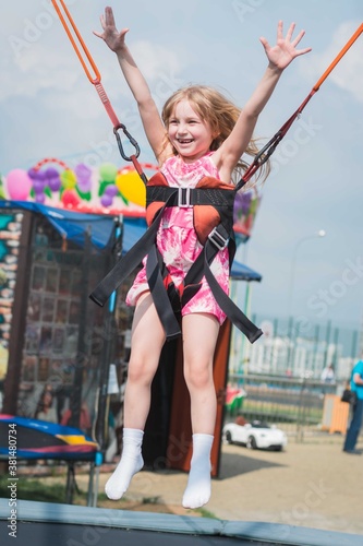 Little girl child riding on a swing in the playground