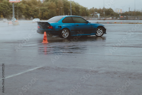 Cars are drifting in the old parking lot. Rain drift. Gray photo processing, atmosphere. Racing in the city.